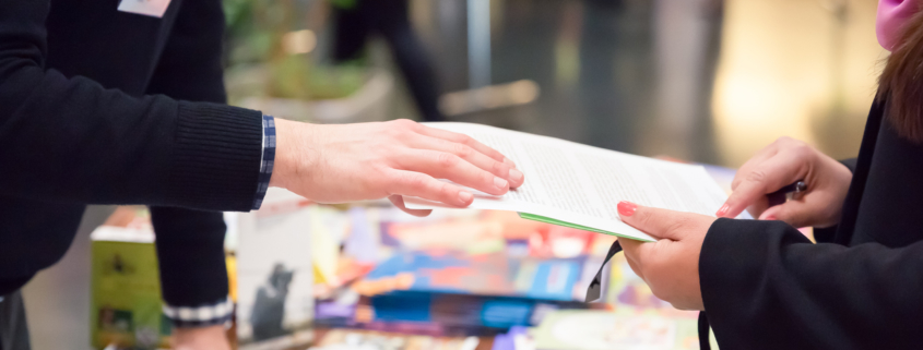 Man and Woman Sharing Information Leaflet over Exhibition Stand